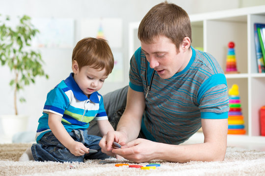 dad and kid playing toys at home