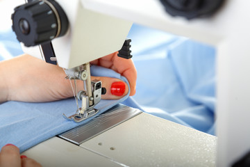 Working on sewing machine. Close look of hands and needle