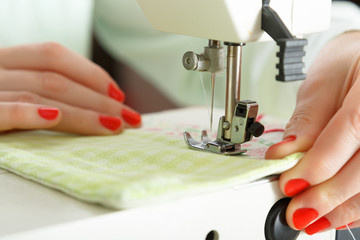 Working on sewing machine. Close look of hands and needle