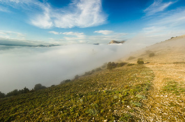 creeping fog in mountain valley at sunset