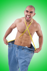 Fototapeta premium Man in dieting concept with oversized jeans