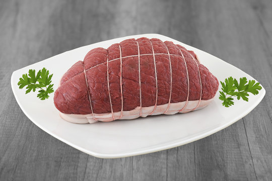 rosbeef cru pr&eacute;sent&eacute; sur assiette fond en bois