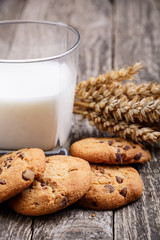 Tasty cookies with milk on a wooden table.
