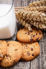Tasty cookies with milk on a wooden table.