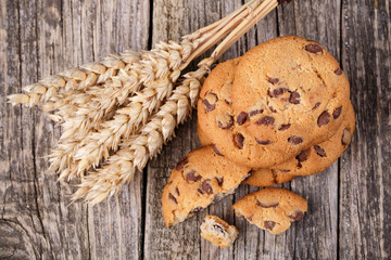 Tasty cookies with wheat on a wooden table.