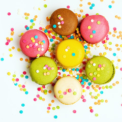 Sweet colorful macaroons against pink background. Top view