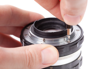 Technician repairing old lens, removing lens mount