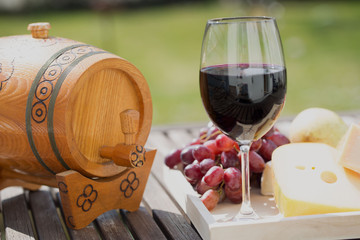 Weinfass mit Weinglas, Käse und Trauben