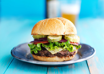 cheeseburger with beer in the background