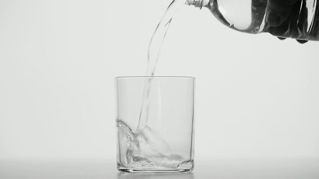 Close up of pouring water in a transparent glass