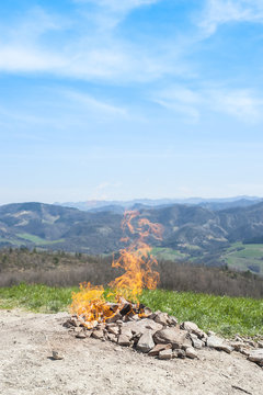 Kampvuur op bergtop met wijds berglandschap