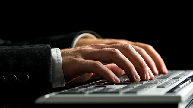 Businessman working on computer by typewriting on the keyboard