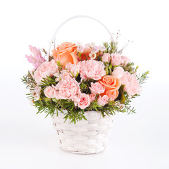beautiful bouquet of pink carnation and roses in basket isolated