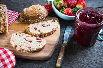 Spreading bread with fresh homemade strawberry jam
