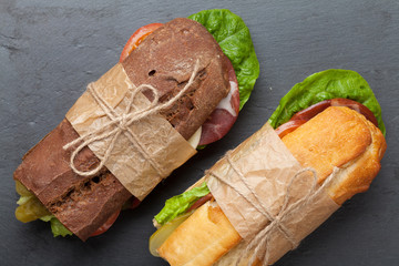 Two sandwiches with salad, ham, cheese and tomatoes