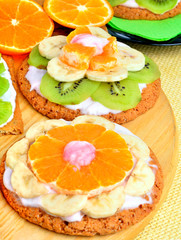 Fruit dessert with exotic fruits and lavender flowers on a woode