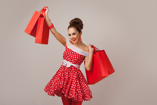 Happy Woman Holding Up Shopping Bags. Pin-up retro style.