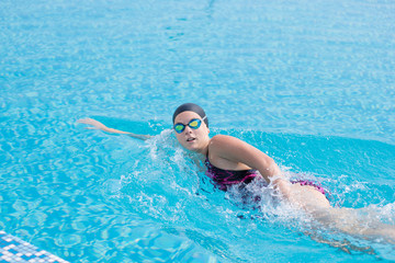 Fototapeta na wymiar Woman in goggles swimming front crawl style