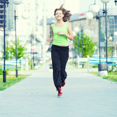 Woman jogging in city street park.