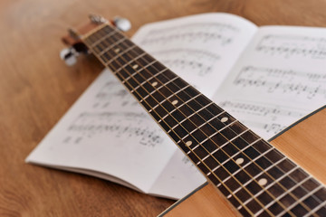 Fototapeta na wymiar Acoustic guitar with notes of song on wooden floor. Guitar chord
