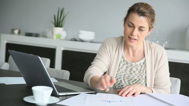 Businesswoman teleworking from home using laptop