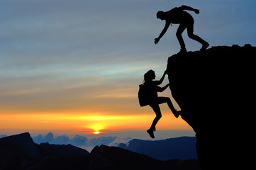 Teamwork of two people man and girl on mountain