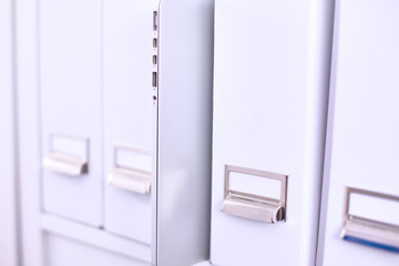 File folders, standing on  shelves in the background