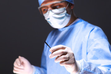 Man surgeon holds a scalpel in an operating room