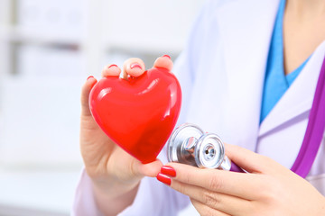 Doctor with stethoscope examining red heart