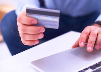 Businessman using his credit card for an online transaction