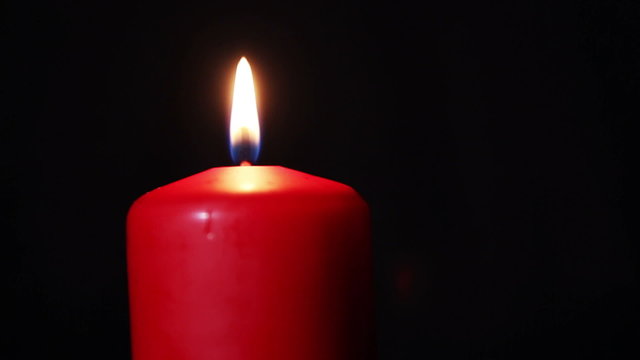 One candle burns brightly in the dark. HD 1080p video in motion