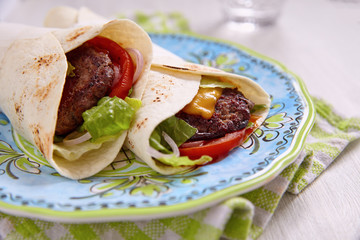 Fresh tortilla wrap with grilled beef burger