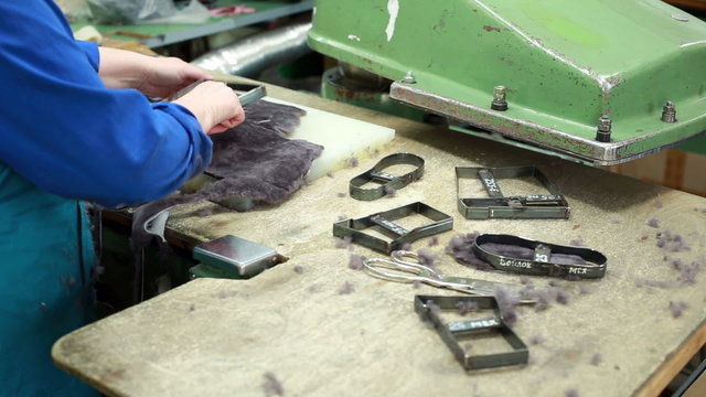 Worker cuts fur details for footwear production