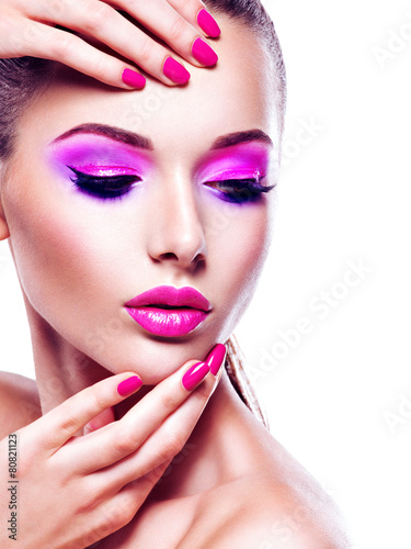 "Face of a beautiful woman with vivid eye make-up and pink nail" Stock