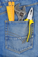 Job concept - tool in blue jeans pocket