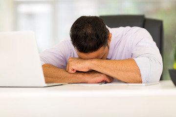middle aged businessman sleeping at work