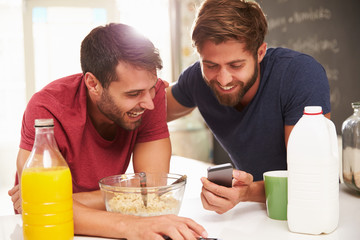 Two Male Friends Having Breakfast And Reading Text Message