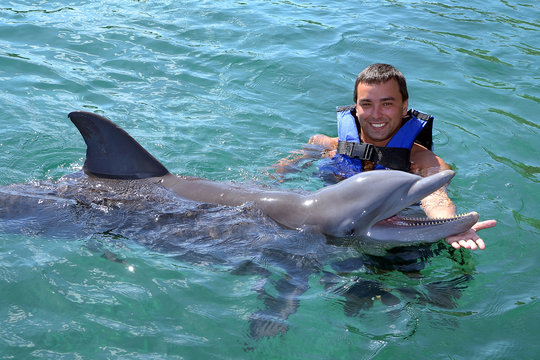 Happy man swim with dolphin