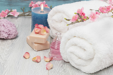 Spa setting with rose petals,natural soap,candle and towel