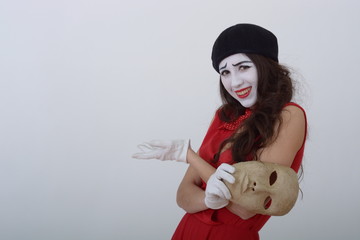 the girl is MIME holding a white theatrical mask and smiles