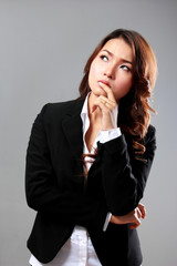 Young businesswoman thinking, looking above