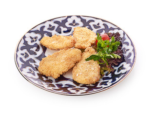 pile of chicken nuggets on white plate with sauce