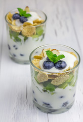 Yogurt dessert with blueberry, kiwi and cereals in the glass