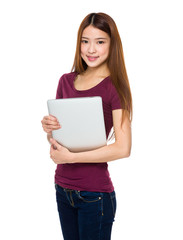 Fototapeta premium Attractive smiling young woman holding laptop computer