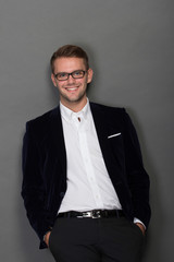 Young businessman leaning on the wall in work suit