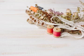 Obraz na płótnie Canvas Sewing kit with flowers on a wooden background