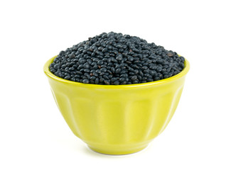 black lentils in a bowl isolated on white