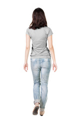 Fototapeta premium back view of walking woman in jeans .