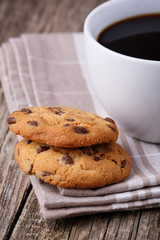 Cup of coffee with cookies on a wooden table.
