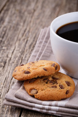 Cup of coffee with cookies on a wooden table.